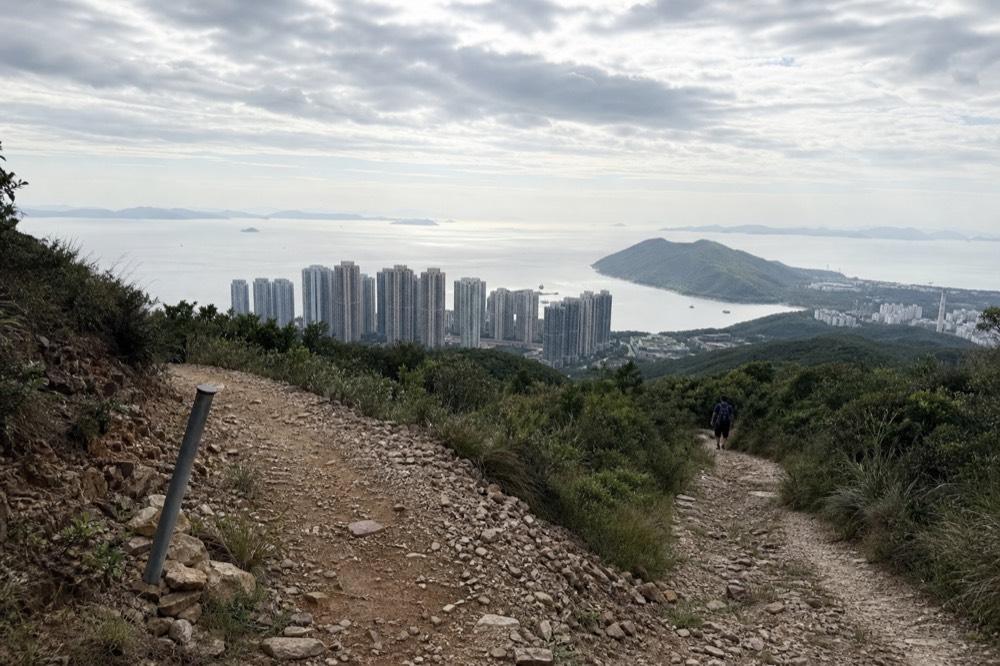 A hillside path above the Lantau coast with open water in the distance, no text, no logos, no people