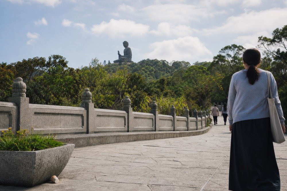 The Tian Tan Buddha seen from the Ngong Ping plateau path, no text, no logos, no people