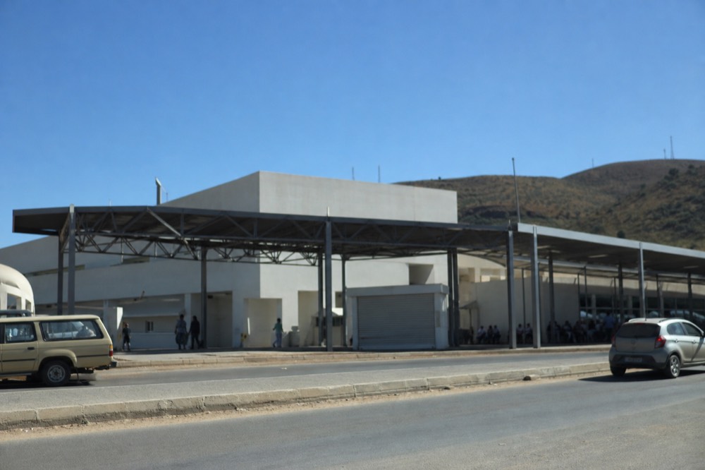 A cable car terminal exterior on a clear day with hills behind, no text, no logos, no people.