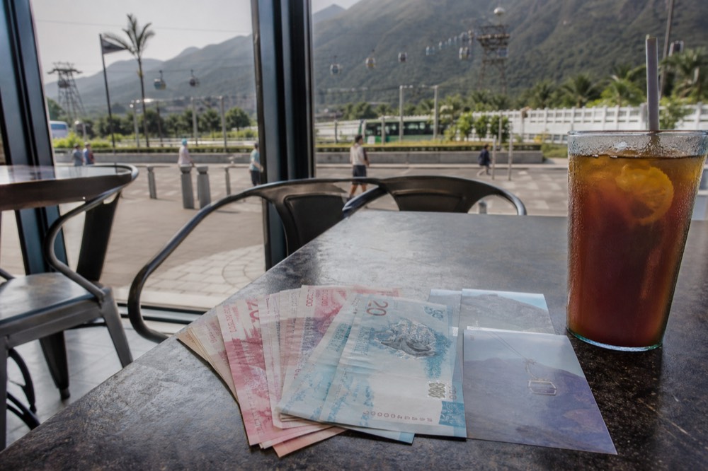 Hong Kong dollar notes and Disneyland ticket next to cable car ticket, no text, no logos, no people